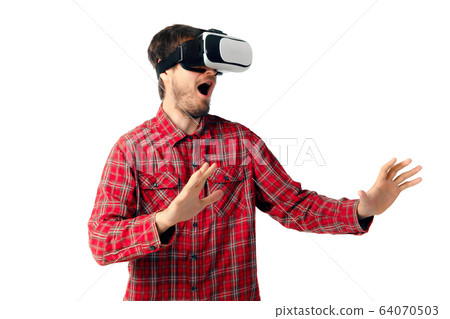 Man emotional playing, using virtual reality headset isolated on white studio background 64070503