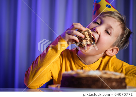 Happy child takes a piece of celebration cake and Happy child takes a piece of celebration cake and 64070771