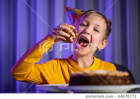 Happy child takes a piece of celebration cake and Happy child takes a piece of celebration cake and 64070772