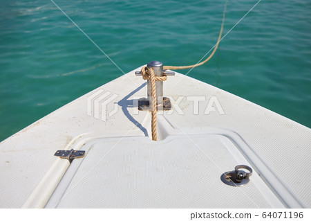 Boat is tied with a rope to the pier Boat is tied with a rope to the pier 64071196