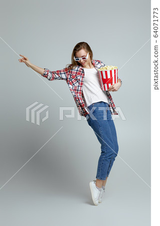woman in red-blue 3d glasses holding bucket with popcorn woman in red-blue 3d glasses holding bucket with popcorn 64071773