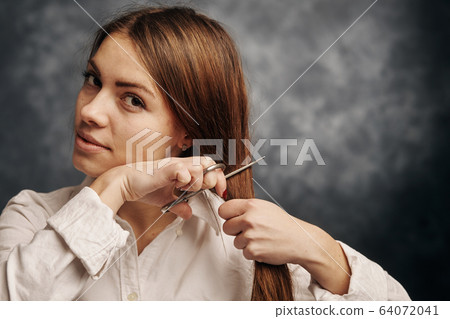 young girl is going to cut her hair 64072041