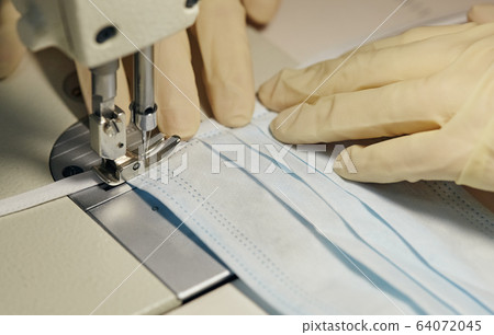 work process of sewing masks for protection against coronavirus 64072045