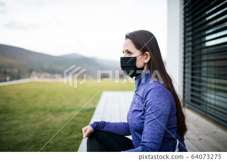 Woman with face masks outdoors at home, Corona virus and quarantine concept. Woman with face masks outdoors at home, Corona virus and quarantine concept. 64073275