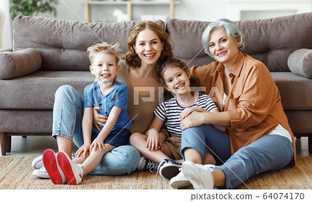 Several generations sitting on floor near sofa. Several generations sitting on floor near sofa. 64074170
