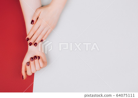 Red manicure on beautiful accurate woman's hands. 64075111