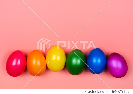 Different colorful eggs in neon trendy colors on coral background. 64075162