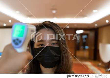 Woman wearing mask protection flu with thermoscan 64075183