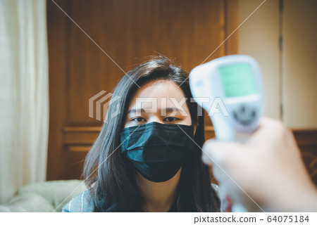 Woman wearing mask protection flu with thermoscan 64075184