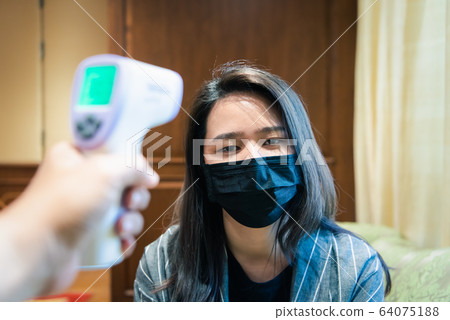 Woman wearing mask protection flu with thermoscan 64075188