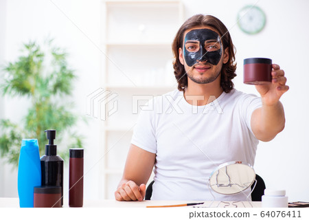Young male cosmetician recording video for his blog Young male cosmetician recording video for his blog 64076411