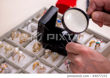 Young woman visiting old male jeweler Young woman visiting old male jeweler 64077241