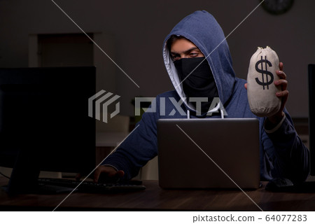 Male hacker hacking security firewall late in office 64077283