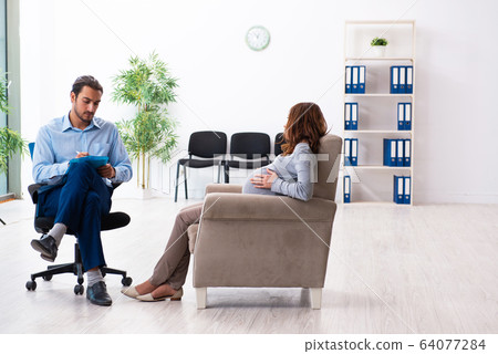 Pregnant woman visiting young male psychologist 64077284