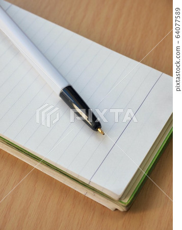白色筆記本和黑色圓珠筆 64077589