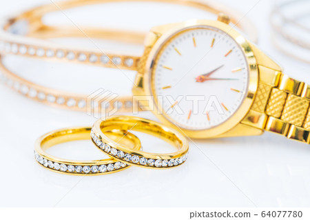 Luxury gold ring and lady gold watch on white 64077780