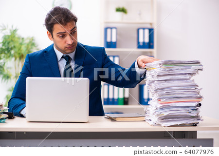 Young male employee unhappy with excessive work Young male employee unhappy with excessive work 64077976