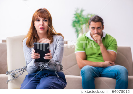 Young couple in gadget dependency concept Young couple in gadget dependency concept 64078015