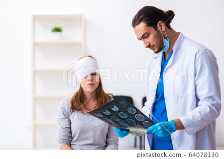 Young head injured woman visiting young male doctor Young head injured woman visiting young male doctor 64078130