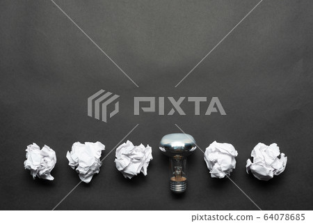 Lightbulb and crumpled white paper balls Lightbulb and crumpled white paper balls 64078685