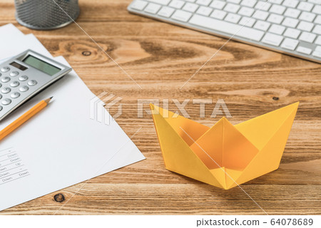 Workspace with office desk and yellow paper ship Workspace with office desk and yellow paper ship 64078689