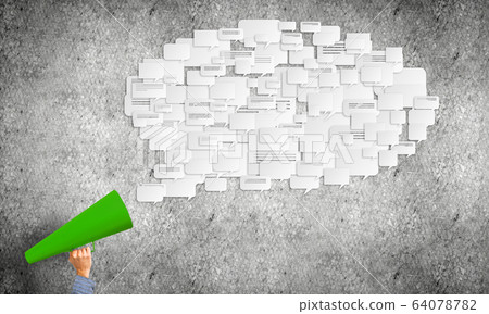 Hand of man holding green paper trumpet against concrete background Hand of man holding green paper trumpet against concrete background 64078782