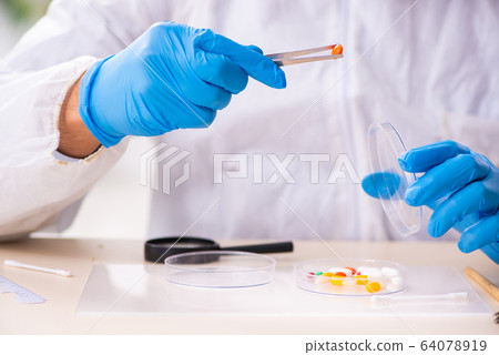 Male expert criminologist working in the lab for evidence Male expert criminologist working in the lab for evidence 64078919