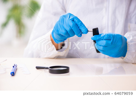 Male expert criminologist working in the lab for evidence 64079059