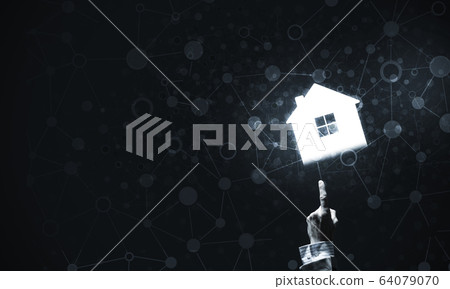 Conceptual image with hand pointing at house or main page icon o 64079070