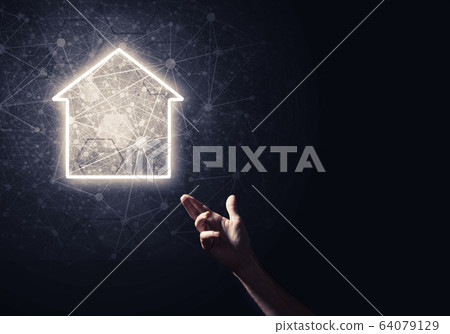 Conceptual image with hand pointing at house or main page icon o 64079129