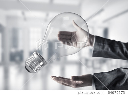 Good idea concept by means of lightbulb in hands. Good idea concept by means of lightbulb in hands. 64079273