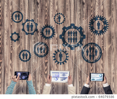 Top view of businesspeople sitting at table and using gadgets Top view of businesspeople sitting at table and using gadgets 64079386
