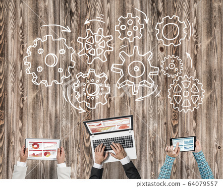 Top view of businesspeople sitting at table and using gadgets Top view of businesspeople sitting at table and using gadgets 64079557