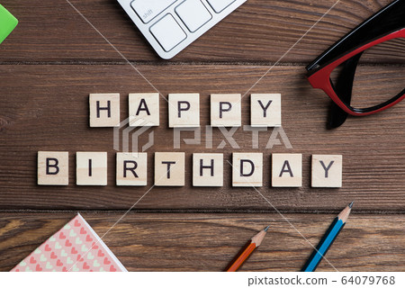 Office stuff and wooden cubes on workplace table making Happy Birthday phrase Office stuff and wooden cubes on workplace table making Happy Birthday phrase 64079768