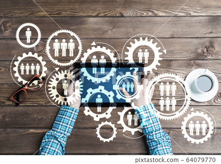 Concept of teamworking and connection with gears mechanism and tablet pc Concept of teamworking and connection with gears mechanism and tablet pc 64079770