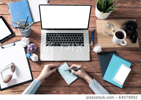 Woman writing in notebook with pen at desk Woman writing in notebook with pen at desk 64079892