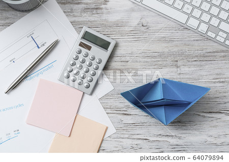 Office workspace with blue paper ship 64079894