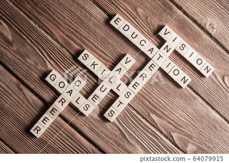Conceptual keywords on wooden table with elements of game making crossword 64079915