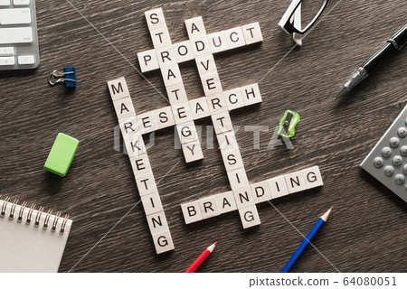 Business workplace with office stuff and wooden cubes making crossword 64080051