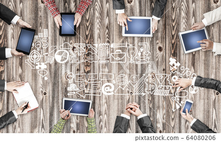 Top view of businesspeople sitting at table and using gadgets Top view of businesspeople sitting at table and using gadgets 64080206