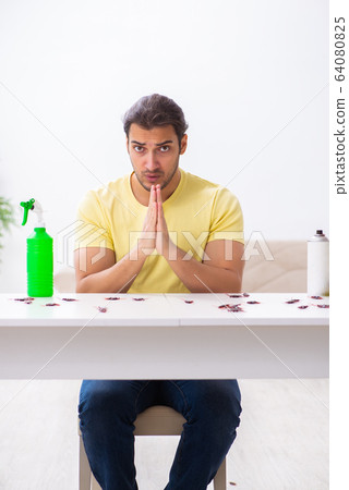 Young man and a lot of cockroaches at home 64080825
