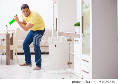 Young man and a lot of cockroaches at home 64080849