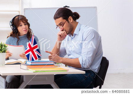 Young female student and male english teacher in the classroom Young female student and male english teacher in the classroom 64080881