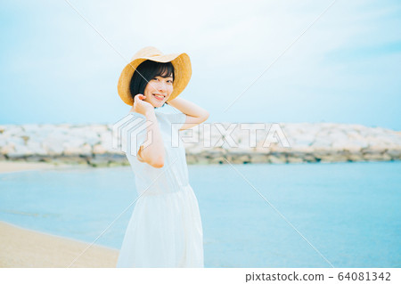 Young woman walking on the seaside Young woman walking on the seaside 64081342