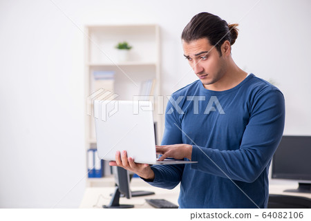 Young male it specialist working in the office 64082106