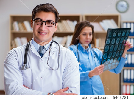 Young doctor looking at computer tomography x-ray image 64082811