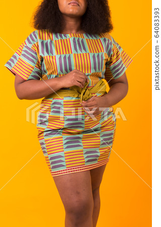 Young beautiful african american girl close-up with an afro hairstyle. Portrait on yellow background. Young beautiful african american girl close-up with an afro hairstyle. Portrait on yellow background. 64083393