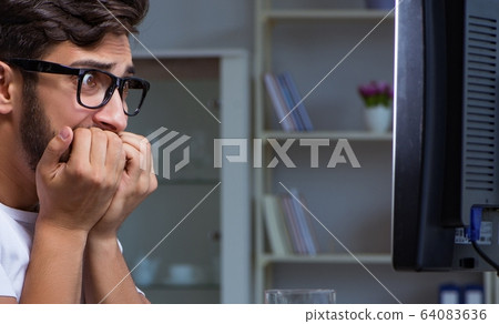 Young man staying late in office to do overtime work Young man staying late in office to do overtime work 64083636