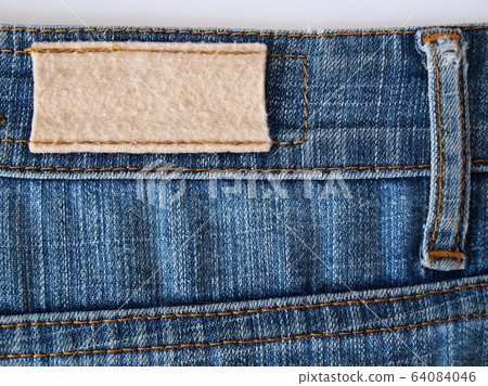 Close-up of old worn-out jeans label. Close-up of old worn-out jeans label. 64084046