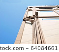 Gray drain pipe on the building's wall in the view below. Gutters and ventilation pipes are installed on the building walls on a blue sky background with copy space. Selective focus 64084661